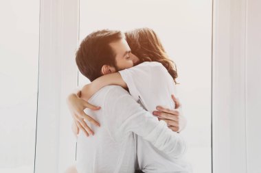 güzel genç çift tutkuyla zemin üzerine güneş ışığı ile sarılma