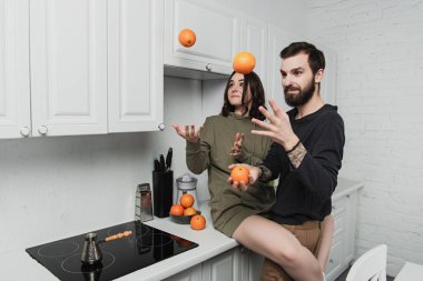 Eğleniyor ve portakal mutfak ile hokkabazlık güzel genç Çift