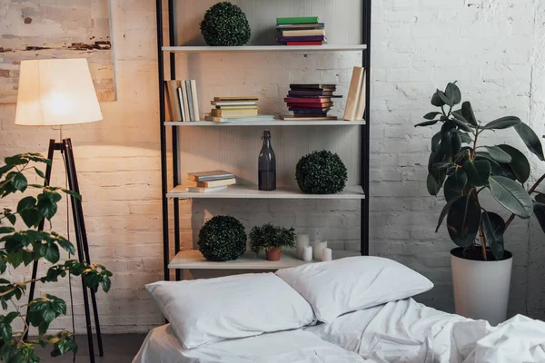 Moderne Indretning Soveværelse Med Rack Planter Lampe Seng Mursten Væg - Stock-foto