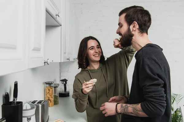 Beautiful Smiling Woman Feeding Handsome Man Toast Breakfast Kitchen — Stock Photo, Image