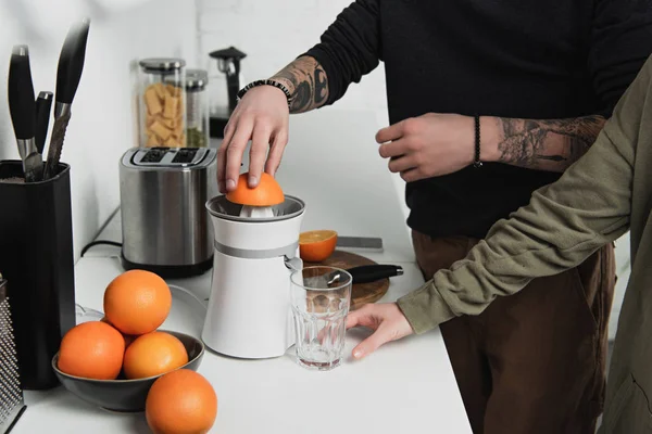 Частичный Вид Пары Готовящей Апельсиновый Сок Время Завтрака Кухне — стоковое фото