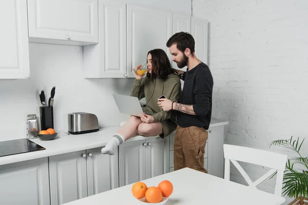 Hombre Abrazando Mujer Usando Ordenador Portátil Beber Jugo Naranja Durante —  Fotos de Stock