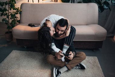 sarılma ve öpüşme kadın oturma odasında joystick ile oyun video oyunu dostum