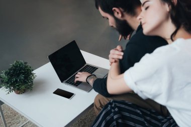 evde boş ekran ile dizüstü bilgisayar kullanırken sarılma çift oturma ang 