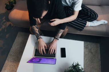 Çift oturma ang ekran evde internet sitesinde alışveriş web ile dizüstü bilgisayar kullanırken sarılma görünümünü kırpılmış 