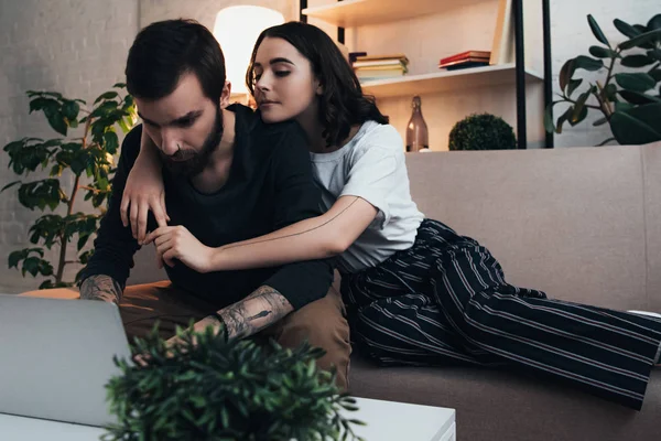 Woman Sitting Couch Hugging Man Using Laptop Living Room — Stock Photo, Image