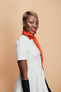 beyaz elbise ve kırmızı eşarp bej izole poz gülümseyen afrikalı amerikalı model