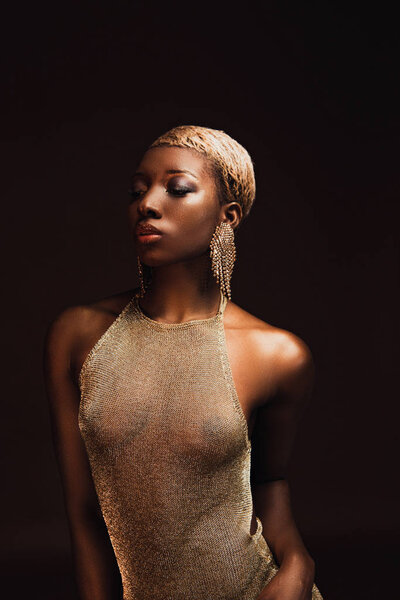 beautiful african american woman with short hair in glamorous dress isolated on brown