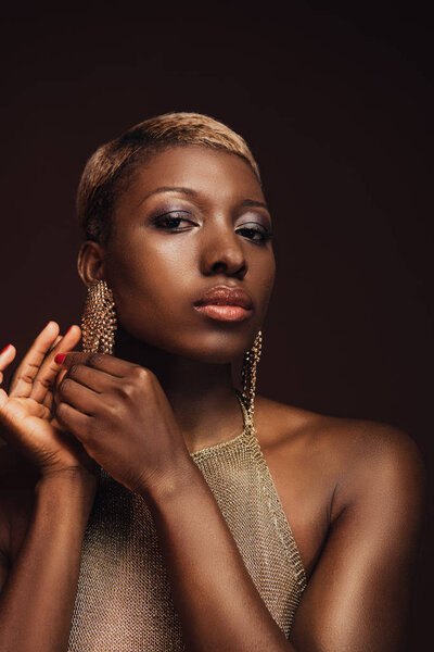 beautiful glamor african american woman with earrings isolated on brown