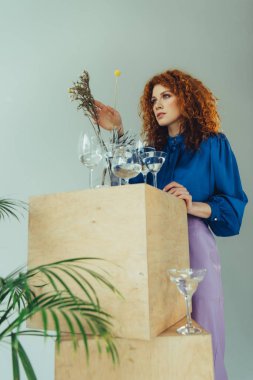 gri üzerinde gözlük ve kurutulmuş çiçekler ile ahşap kutular yakın poz şık Redhead kız
