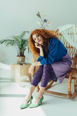 gri üzerinde saksı ve kurutulmuş çiçekler yakın hasır sandalyede oturan şık Redhead kız