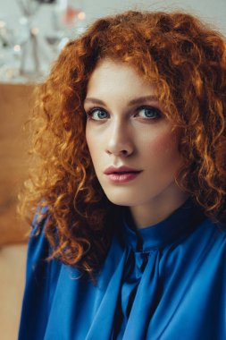 çekici şık Redhead genç kadın kamera bakarak seçici odak