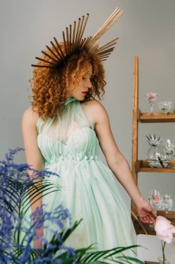 gri üzerinde izole çiçekler ve gözlük ile merdiven yakın poz kafa üzerinde aksesuar ile şık Redhead kız