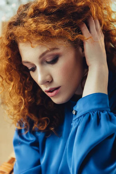 beautiful fashionable young redhead woman touching hair