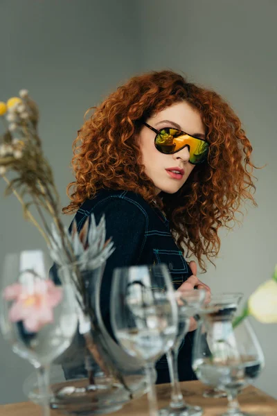 Mujer Pelirroja Con Estilo Gafas Sol Posando Cerca Gafas Flores — Foto de Stock