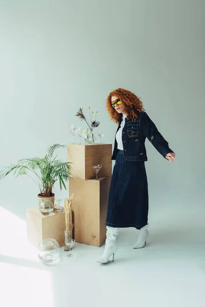 Trendy Redhead Girl Posing Wooden Boxes Glasses Plants Grey — Stock Photo, Image