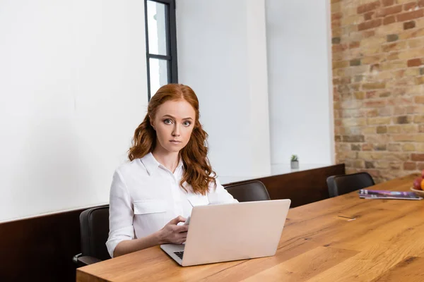 Beautiful Woman Looking Camera While Using Smartphone Ear Laptop Table — Stock Photo, Image