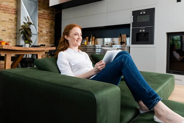 Mujer Sonriente Sosteniendo Tableta Digital Sofá Casa —  Fotos de Stock