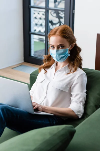 Selective Focus Red Haired Woman Medical Mask Looking Camera While — Stock Photo, Image
