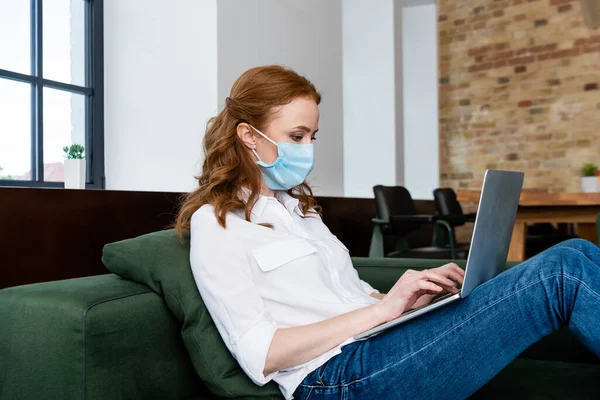 Vista Lateral Del Teletrabajador Máscara Médica Utilizando Ordenador Portátil Sofá — Foto de Stock