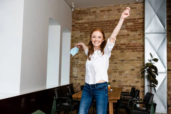 Mujer Alegre Sonriendo Cámara Mientras Sostiene Máscara Médica Sala Estar — Foto de Stock