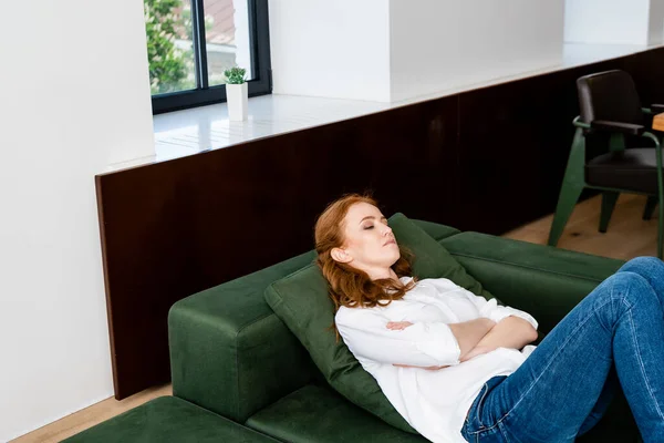 横着双臂躺在沙发上的抑郁女人 — 图库照片