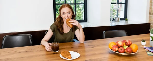 Panoramatická Orientace Ženy Jíst Croissant Držet Šálek Kávy Při Snídani — Stock fotografie