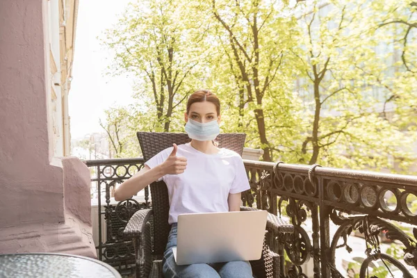 Young Freelancer Medical Mask Sitting Chair Laptop Showing Thumb — Stock Photo, Image