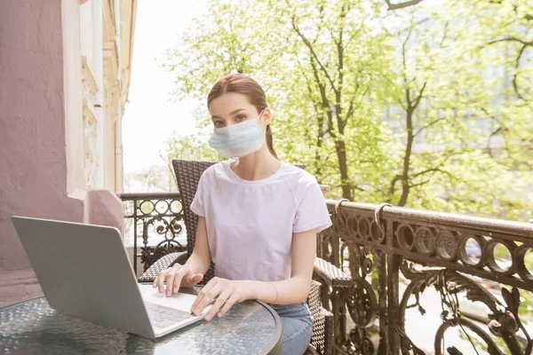 Молода Жінка Медичній Масці Сидить Стільці Використовує Ноутбук Балконі — стокове фото
