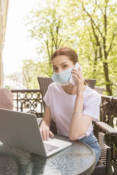 Young Freelancer Medical Mask Talking Smartphone Using Laptop Balcony — Stock Photo, Image