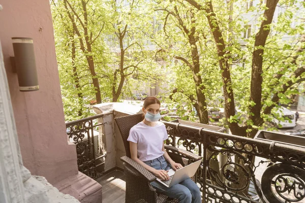 Young Freelancer Medical Mask Sitting Chair Using Laptop Looking Camera — Stock Photo, Image