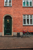 Fahrrad in der Nähe der Ziegelfassade eines Gebäudes an der Stadtstraße in Kopenhagen, Dänemark 