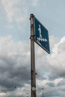 Arka planda bulutlu gökyüzü olan şehir caddesinde alçak açılı merdiven işareti 