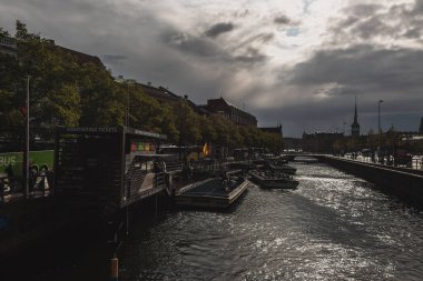COPENHAGEN, DENMARK - 30 Nisan 2020: Kanal suyunda tekneler ve arka planda bulutlu gökyüzü 