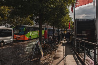 COPENHAGEN, DENMARK - APRIL 30, 2020: Bicycles near trees and road on urban street  clipart