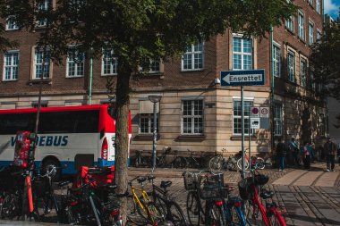 COPENHAGEN, DENMARK - 30 Nisan 2020: Ağaç yakınındaki bisiklet ve şehir caddesindeki binanın ön cephesi 