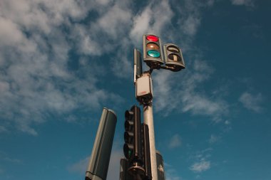 Low angle view of traffic lights with cloudy sky at background  clipart