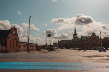 Danimarka 'nın Kopenhag şehrinde Borsen binası cephesi ve bulutlu gökyüzü olan şehir caddesi 