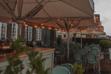 Selective focus of lighting on umbrellas of outdoor cafe in Copenhagen, Denmark  clipart