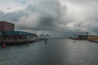 Facade of royal Danish Playhouse and river with cloudy sky at background, Copenhagen, Denmark  clipart