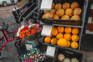 Danimarka 'nın Kopenhag kentsel caddesinde dükkan vitrininde kavunlar ve çiçek buketleri 