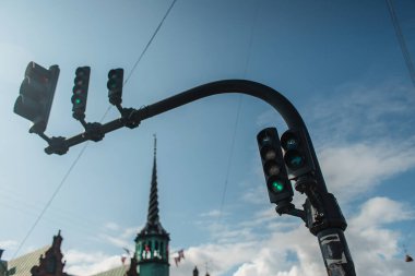 Low angle view of traffic lights with cloudy sky at background on urban street in  Copenhagen, Denmark  clipart