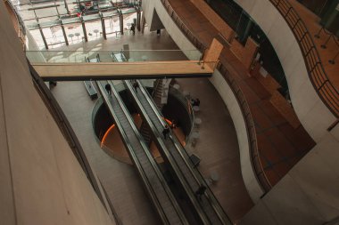 COPENHAGEN, DENMARK - 30 Nisan 2020: Black Diamond Royal Library, Kopenhag, Danimarka 'daki yürüyen merdivenlerdeki insanların yüksek açılı görüntüsü 