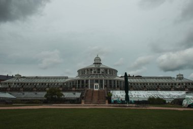 Facade of University of Copenhagen Botanical Garden with cloudy sky at background, Denmark  clipart