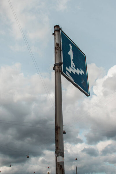 Low angle view of stairs sign on urban street with cloudy sky at background 