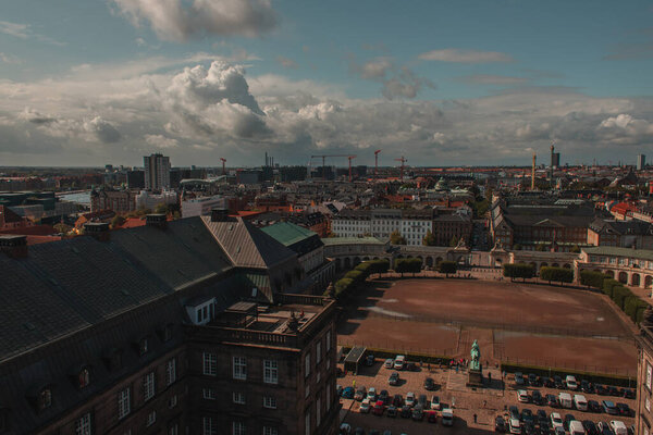 High angle view of field and cars near Christiansborg Palace with cloudy sky at background in Copenhagen, Denmark 