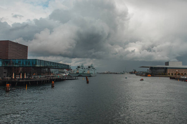 Facade of royal Danish Playhouse and river with cloudy sky at background, Copenhagen, Denmark 