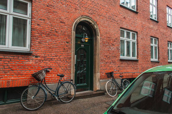 Lighting lantern on door of building with brick facade in Copenhagen, Denmark 