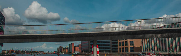 Panoramic shot of bridge with buildings and cloudy sky at background in Copenhagen, Denmark 