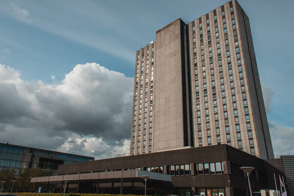Low angle view of facades of building with cloudy sky at background on urban street in Copenhagen, Denmark 